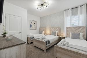 a bedroom with two beds and a dog laying on the bed at Beachside Deluxe in Melbourne Beach +83 photos
