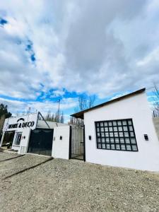 a white building with a sign on the side of it at Encantador monoambiente con parque in Río Gallegos