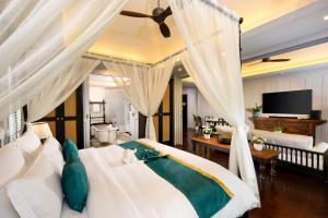 a bedroom with a white bed with a ceiling fan at Siri Village Chiang Mai in Chiang Mai +110 photos