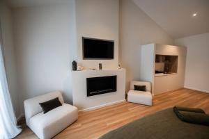 a living room with two chairs and a flat screen tv at Redwood Park - Luxury Off Grid Accommodation in Wollombi