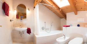 Un baño con lavabo, bañera e inodoro. en Apartment Suliva, en Santa Cristina Valgardena