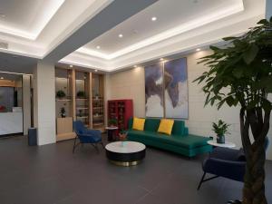 a living room with a couch and a table and chairs at Green Tree Inn Anhui Suzhou Evergrande in Suzhou