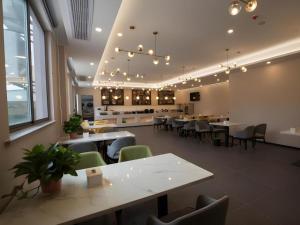 a restaurant with tables and chairs and a cafeteria at Green Tree Inn Anhui Suzhou Evergrande in Suzhou