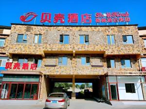 un bâtiment avec une voiture garée devant dans l'établissement Shell Hotel Beijing Miyun District Shuiku Yangguang, à Xiwengzhuang