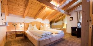 Un dormitorio con una cama grande y un techo de madera. en Apartment Suliva, en Santa Cristina Valgardena