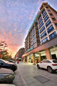 a large building with cars parked in front of it at City Comfort Inn Yunfu Xinxing Juncheng Plaza in Yunfu