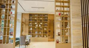 a room with a library with chairs and shelves at City Comfort Inn Yangxin High-speed Railway Station in Huangshi