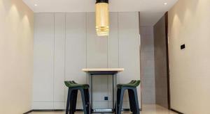 a room with two green stools and a table at City Comfort Inn Yangxin High-speed Railway Station in Huangshi
