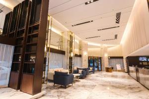a lobby with couches and chairs in a building at Borrman Hotel Yunfu Xinxing County Bus Station in Yunfu
