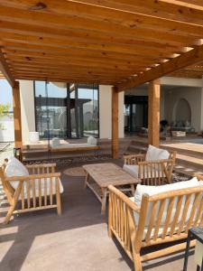 a patio with wooden benches and a table and chairs at Paradise Vine in Barka