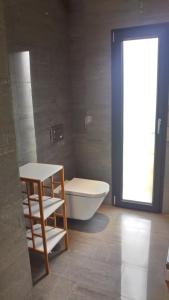 a bathroom with a tub and a toilet and a window at Casa Rio da Prata in Aldeia do Meco