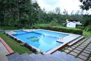 a swimming pool in a yard next to a garden at The Nature's Nest in Attigundi