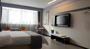a hotel room with a bed and a flat screen tv at Thank Inn Ningxia Yinchuan Helan County Ningxia Jiaotong School in Yinchuan +50 photos