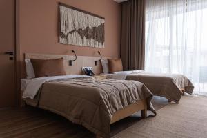 a bedroom with two beds and a large window at Nammu Spa and Wellness in Dubun