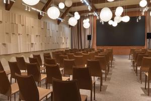 a lecture hall with chairs and a projection screen at Nammu Spa and Wellness in Dubun
