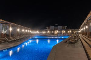 a swimming pool at night with chairs and lights at Nammu Spa and Wellness in Dubun