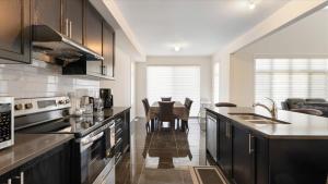 a kitchen with black cabinets and a dining room at Modern Bay Vista Getaways in Carrying Place