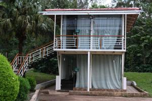 a house with a staircase leading to a balcony at The Nature's Nest in Attigundi