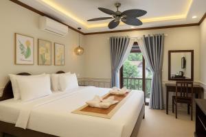 a bedroom with a bed with two towels on it at Villa Khili Phousi in Luang Prabang +86 photos