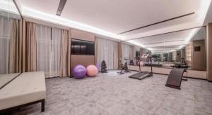 a large room with a gym with exercise equipment at Echeng Hotel Hezhou Shizheng Square in Wuzhou