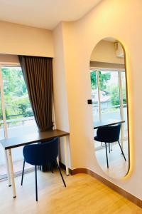 a room with a table and chairs and a mirror at PACINN Narathiwat โรงแรมพักอินน์ นราธิวาส in Kampong Botong
