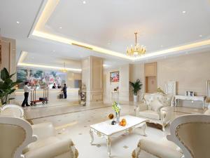 a large living room with white furniture and a chandelier at Vienna Hotel Baoshan Yongchang Road in Baoshan
