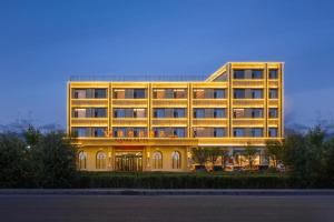 a large yellow building with lights on at Vienna Hotel Qinghai Dachaidan in Da Qaidam