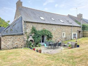 una vista esterna di una casa in pietra con patio di Le Petit Saint-Brieuc - Grand Terrain, 5 min Ville a Caribet