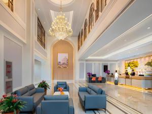 a lobby with blue chairs and a chandelier at Vienna Hotel Beijing Changping Science and Technology Park in Beijing