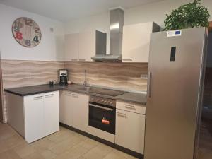 a kitchen with white cabinets and a refrigerator at Sobe Nobiles in Draganići