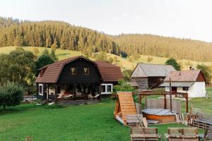 a house in a field with a yard with chairs at Cabana Soarelui,Napos vendégház in Valea Boroş