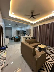 ein Wohnzimmer mit einer Couch und einem Deckenventilator in der Unterkunft Casa Amethyst in Kuala Terengganu