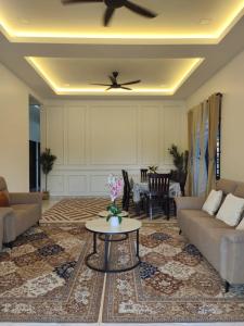 ein Wohnzimmer mit einer Couch und einem Deckenventilator in der Unterkunft Casa Amethyst in Kuala Terengganu + 1 Foto
