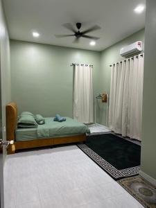 ein Schlafzimmer mit einem Bett und einem Deckenventilator in der Unterkunft Casa Amethyst in Kuala Terengganu