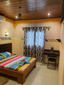 a bedroom with a bed and a desk at Complexe la samaritaine in Yaoundé