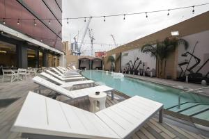 a large swimming pool with white tables and chairs at Ahern Hotel and Event Center in Las Vegas