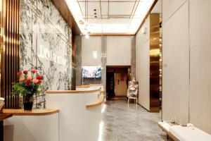 a lobby with a reception desk and a vase of flowers at Poltton International Service Apartment Shanwei Urban District High-speed Railway Station in Shanwei