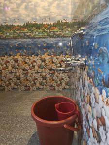 a bucket in front of a wall with a sink at Lakshika tent stay in Gokarna