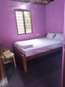 a bedroom with a large bed in a purple room at Lakshika tent stay in Gokarna