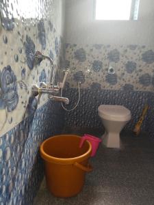 a bathroom with a bucket next to a toilet at Lakshika tent stay in Gokarna