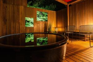 a wooden deck with a hot tub and a table at 清水いにしえ庵 in Kyoto