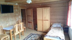 a room with a bed and a tv and a table at Pokoje Gościnne Pod Grapą in Poronin