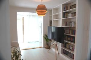 a living room with a book shelf with books at WhiteTreeHouse 