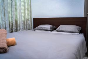 ブキッ・ムルタジャムにあるGARDEN COZY2STOREY HOME 4ROOM 10PAX@NEAR ALMAJUSCOの寝室にある白いシーツと枕が置かれたベッド