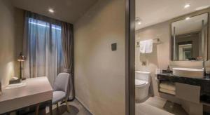 un bagno con un water, un lavandino e uno specchio di City Comfort Inn Hotel Wuhan Optics Valley Square Metro Station Zhongnan Minzu University a Wuhan Altre 252 foto