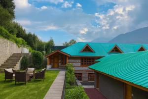 a house with a turquoise roof and some chairs at Snow Clad Riverview Hotel & Resort, Manali in Manāli +34 photos