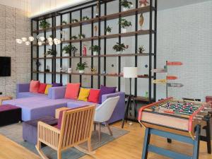 ShenzhenにあるCampanile Hotel Shenzhen Bay Convention and Exhibition Centerの紫色のソファとチェス盤が備わるリビングルーム