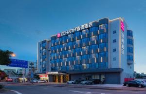 a building on a street with cars parked in front of it at Echarm Hotel Shenzhen International Exhibition Center Fuyong in Shenzhen