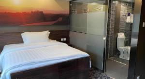 a bedroom with a bed and a glass shower at J Link Hotel in Hong Kong