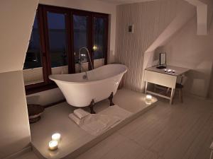 a white bath tub in a bathroom with a table at Seeblick Cottage in Ziemitz +60 photos